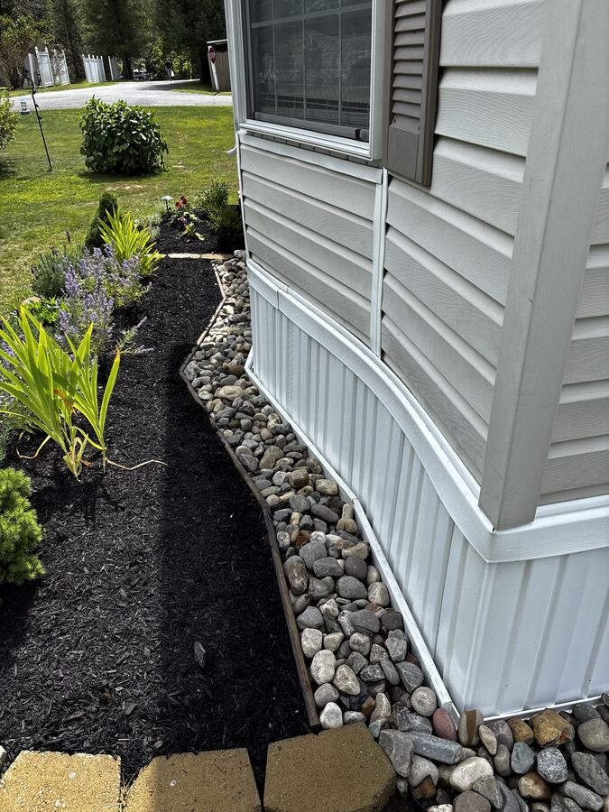 River rock drainage border along home foundation